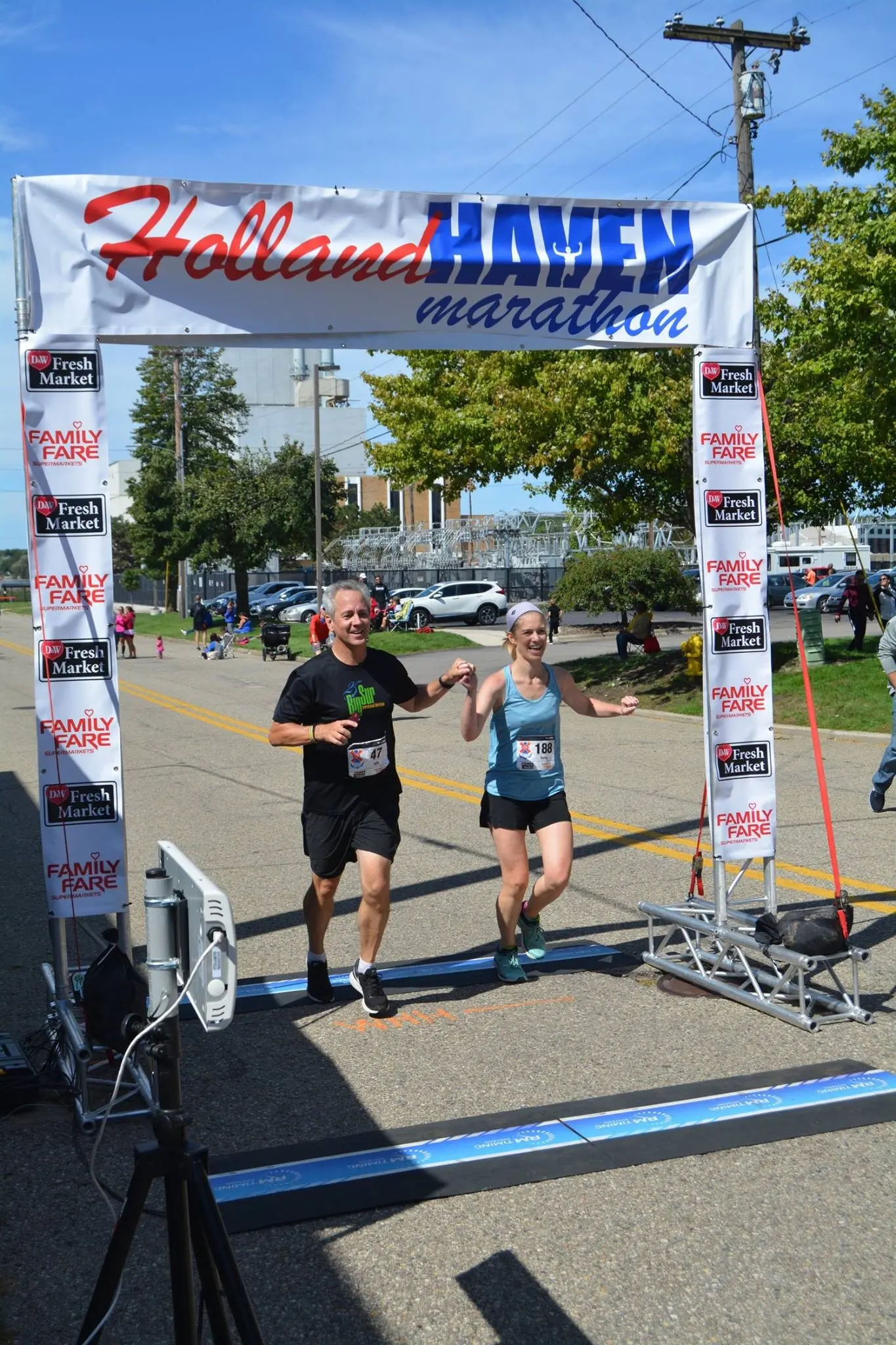 Two runners cross the Holland Haven finish line together